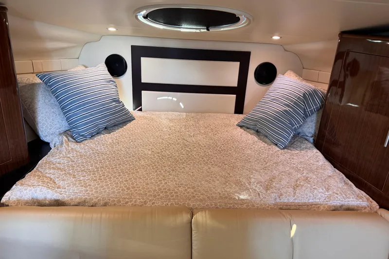  Yacht Photos Pics Cozy cabin interior of 2015 Regal 32 Express with striped pillows and elegant bedding.