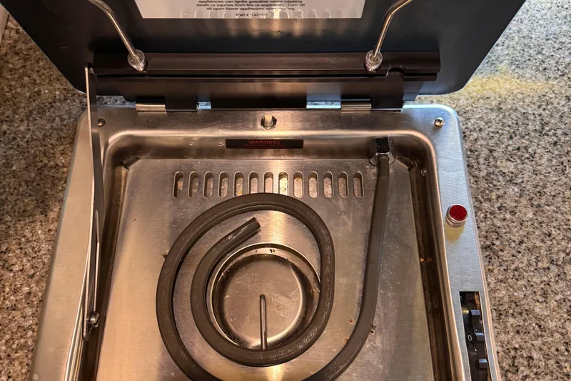  Yacht Photos Pics Open stainless steel appliance with coiled heating element on granite countertop.