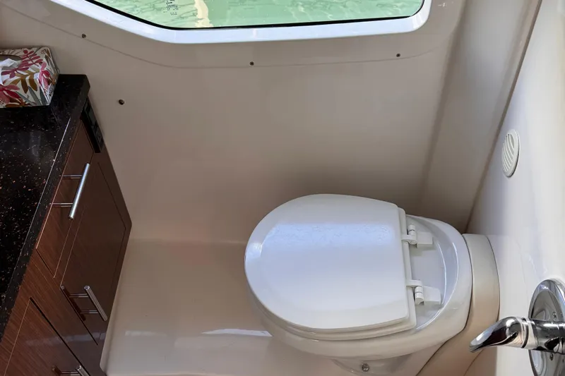  Yacht Photos Pics 2015 Regal 32 Express boat bathroom with toilet and wooden cabinet.