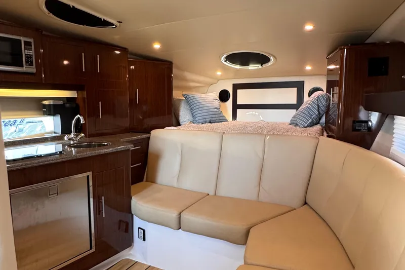  Yacht Photos Pics Luxurious interior of 2015 Regal 32 Express yacht with kitchenette and cozy seating area.