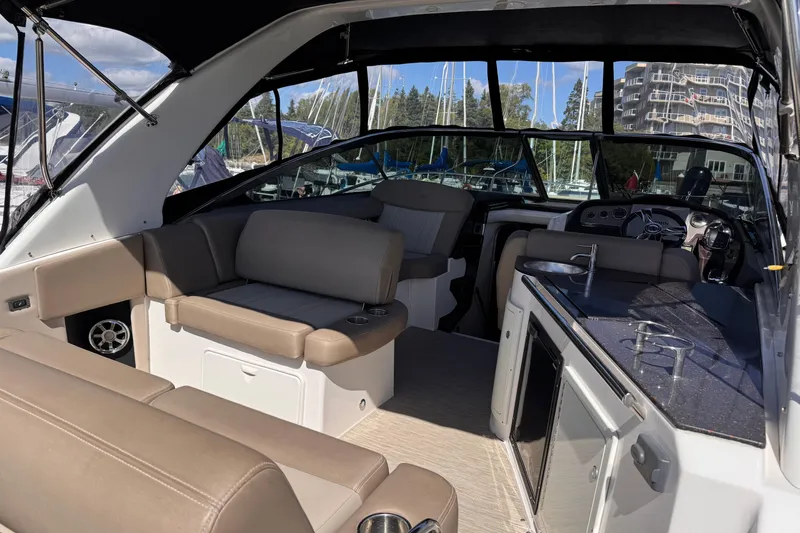  Yacht Photos Pics 2015 Regal 32 Express boat interior with seating, kitchenette, and helm, docked at marina.