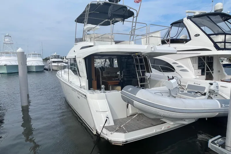 A To Z Yacht Photos Pics 2018 Beneteau Swift Trawler 35 docked, featuring a dinghy and spacious deck area.