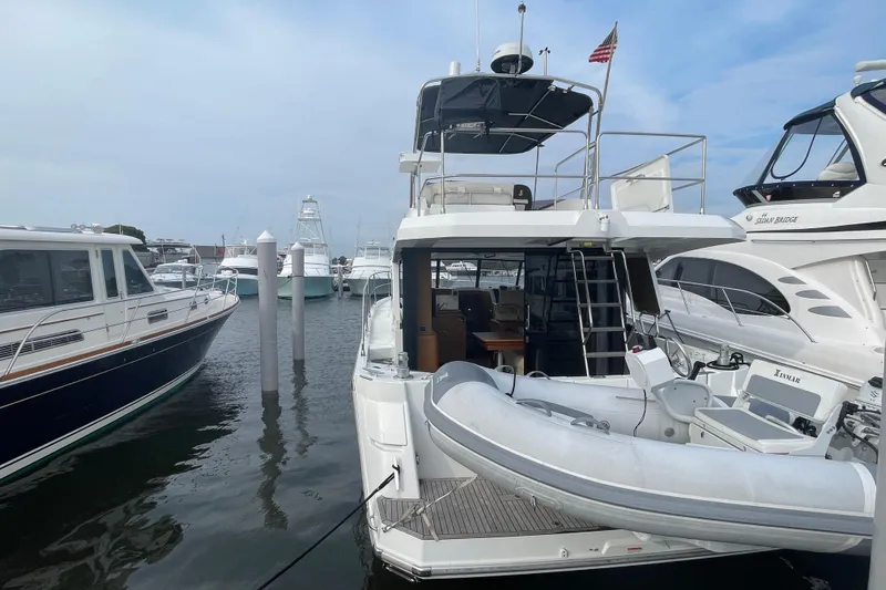 A To Z Yacht Photos Pics 2018 Beneteau Swift Trawler 35 docked, featuring a dinghy and spacious deck area.