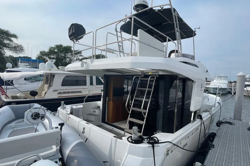 A To Z Yacht Photos Pics 2018 Beneteau Swift Trawler 35 docked, featuring upper deck and inflatable boat.