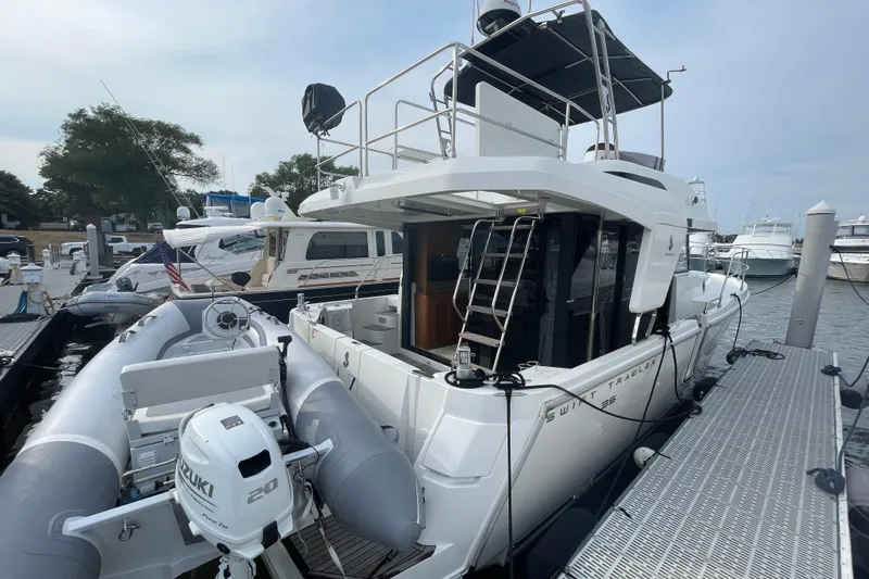 A To Z Yacht Photos Pics 2018 Beneteau Swift Trawler 35 docked with inflatable boat and Suzuki motor.
