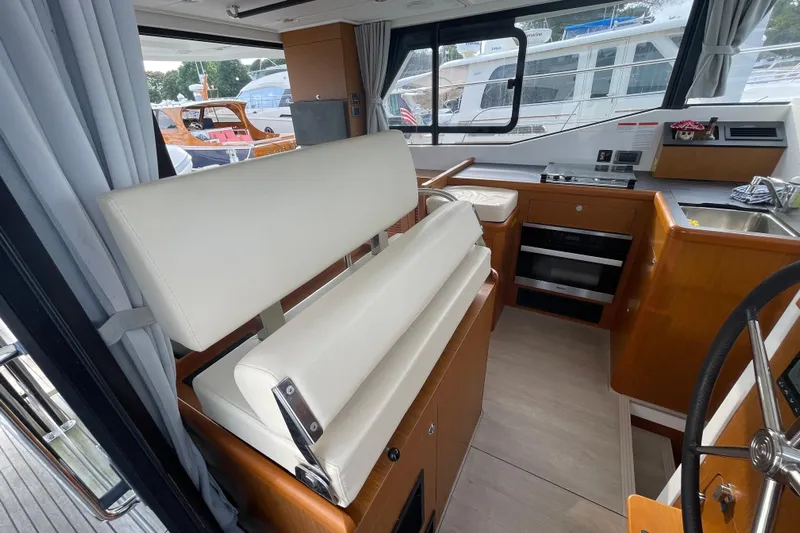 A To Z Yacht Photos Pics Interior of 2018 Beneteau Swift Trawler 35, featuring helm, seating, and kitchen area.