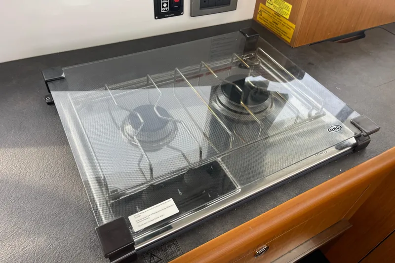 A To Z Yacht Photos Pics Gas stove on 2018 Beneteau Swift Trawler 35, featuring protective glass cover.