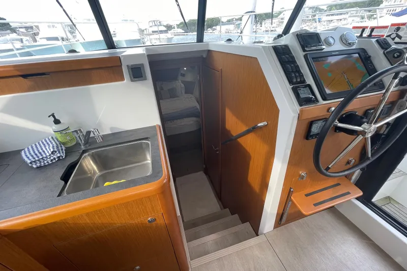 A To Z Yacht Photos Pics 2018 Beneteau Swift Trawler 35 interior with helm, sink, and navigation equipment.
