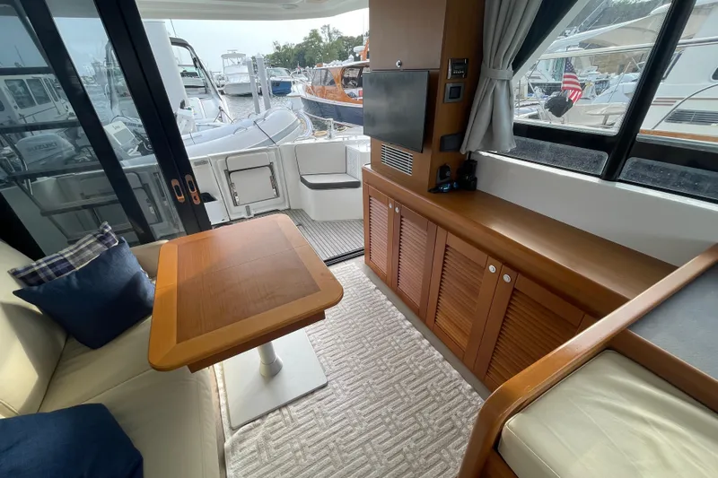 A To Z Yacht Photos Pics 2018 Beneteau Swift Trawler 35 interior with wooden table, seating, and marina view.