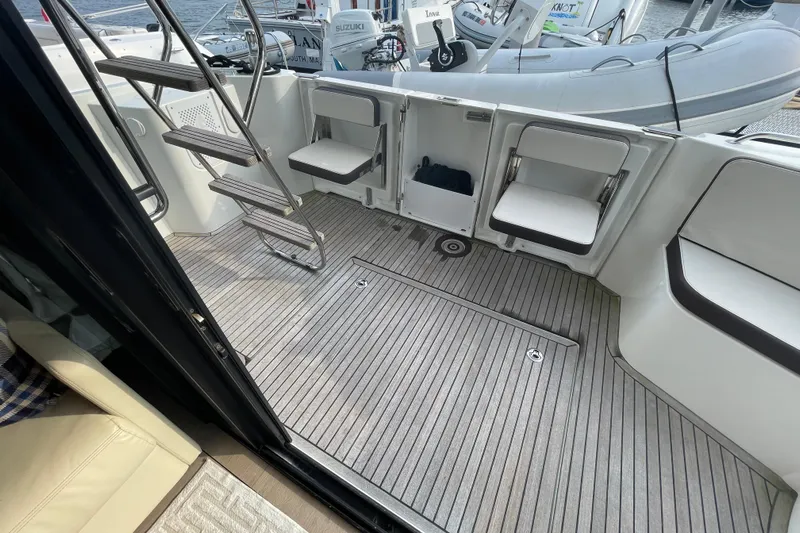 A To Z Yacht Photos Pics 2018 Beneteau Swift Trawler 35 deck with seating and ladder, featuring a modern design.
