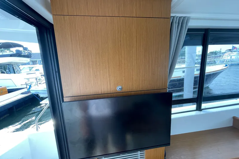 A To Z Yacht Photos Pics Interior of 2018 Beneteau Swift Trawler 35 with mounted TV and marina view.