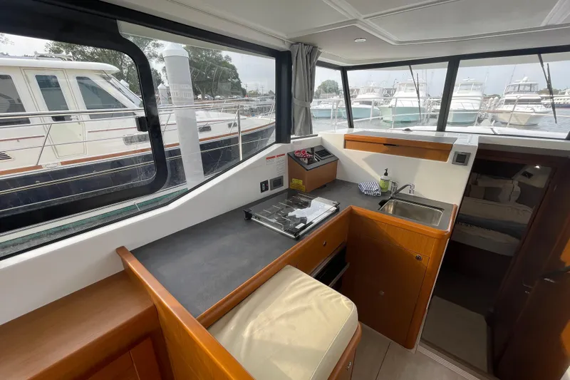 A To Z Yacht Photos Pics Interior of 2018 Beneteau Swift Trawler 35 with kitchenette and marina view.