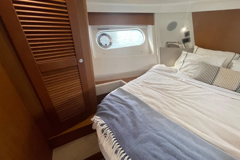 A To Z Yacht Photos Pics Cozy bedroom interior of 2018 Beneteau Swift Trawler 35 with window and wooden accents.