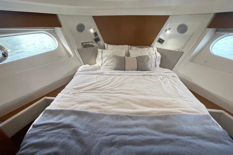 A To Z Yacht Photos Pics Cozy bedroom in 2018 Beneteau Swift Trawler 35 with elegant bedding and porthole views.