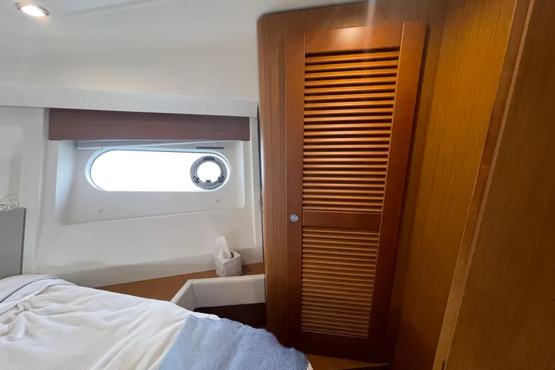 A To Z Yacht Photos Pics Interior cabin of 2018 Beneteau Swift Trawler 35 with wooden closet and porthole window.