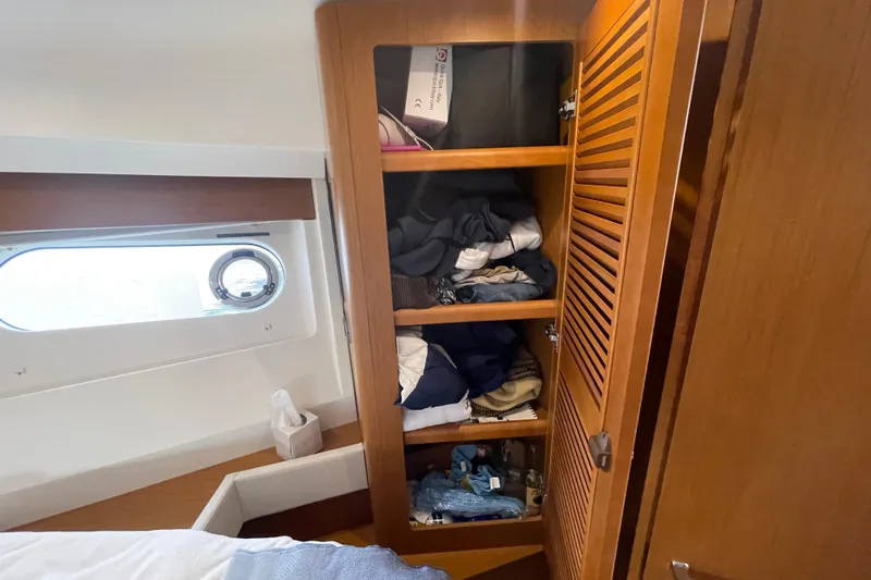 A To Z Yacht Photos Pics Wooden closet with clothes inside a 2018 Beneteau Swift Trawler 35 cabin.