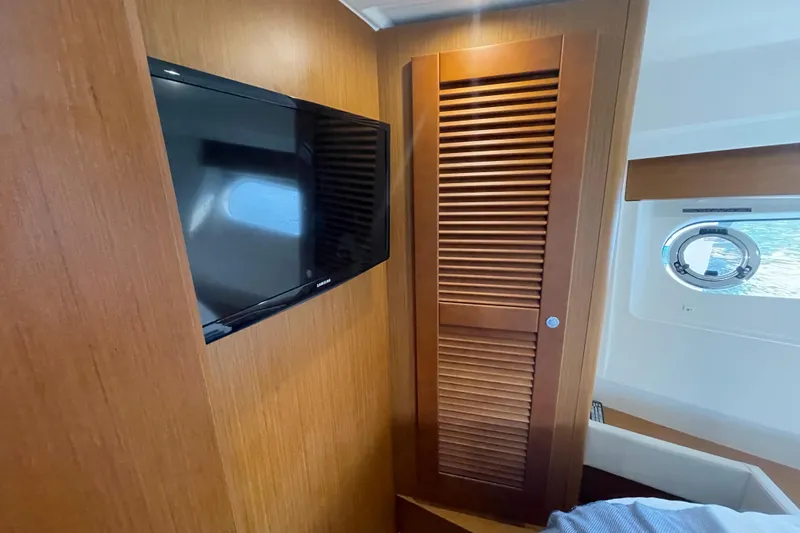 A To Z Yacht Photos Pics 2018 Beneteau Swift Trawler 35 interior with TV, wooden paneling, and porthole window.