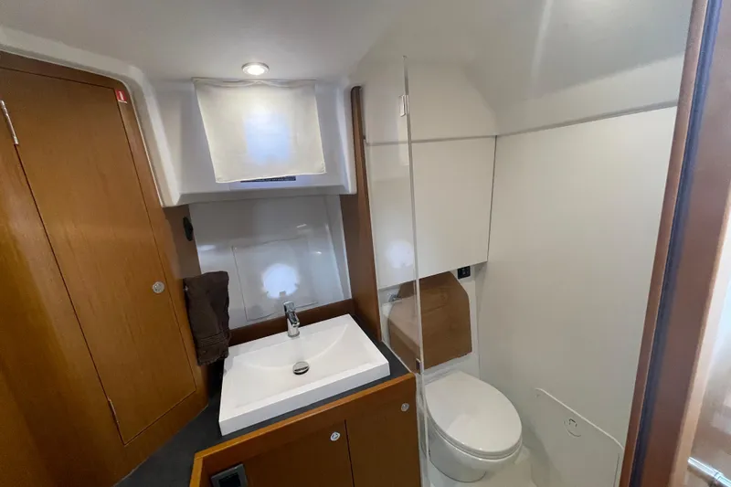 A To Z Yacht Photos Pics 2018 Beneteau Swift Trawler 35 bathroom with sink, toilet, and wooden cabinetry.