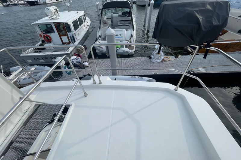 A To Z Yacht Photos Pics 2018 Beneteau Swift Trawler 35 docked, with boats and "For Sale" sign visible.