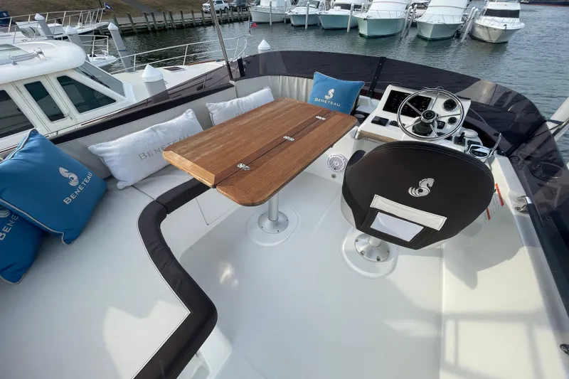 A To Z Yacht Photos Pics 2018 Beneteau Swift Trawler 35 flybridge with seating, table, and helm station.