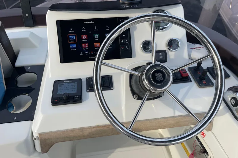 A To Z Yacht Photos Pics 2018 Beneteau Swift Trawler 35 helm with Raymarine navigation system and steering wheel.