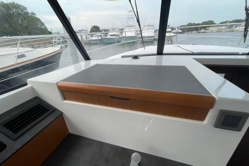 A To Z Yacht Photos Pics 2018 Beneteau Swift Trawler 35 helm station with marina view in the background.