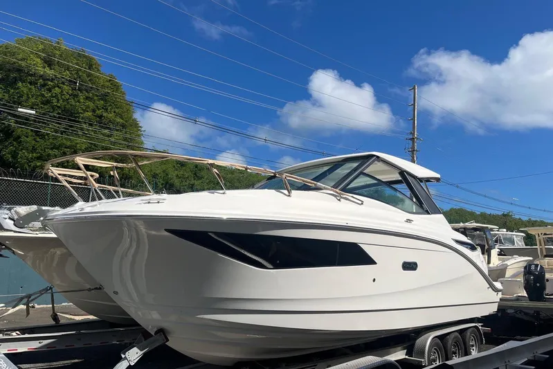  Yacht Photos Pics 2026 Sea Ray Sundancer 320 Outboard boat on trailer under clear blue sky.