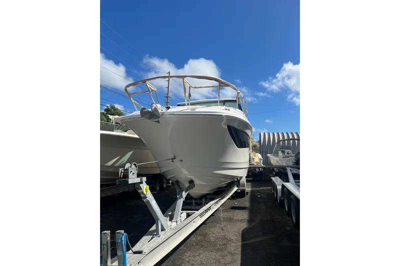  Yacht Photos Pics 2026 Sea Ray Sundancer 320 Outboard on trailer under clear blue sky.