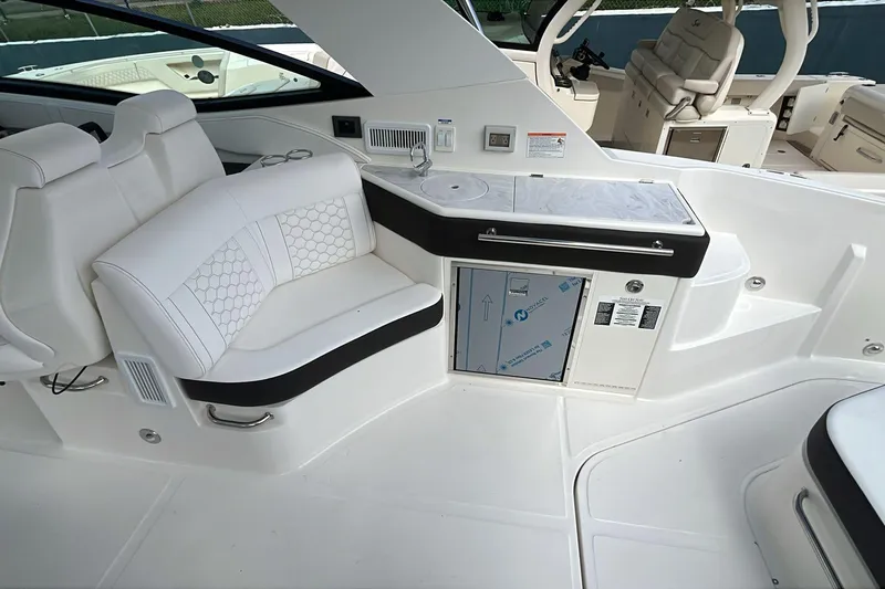  Yacht Photos Pics Interior of 2026 Sea Ray Sundancer 320 Outboard with white seating and kitchenette area.