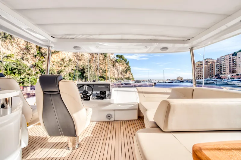  Yacht Photos Pics Interior view of 2016 Princess 68 yacht with luxurious seating and scenic marina backdrop.