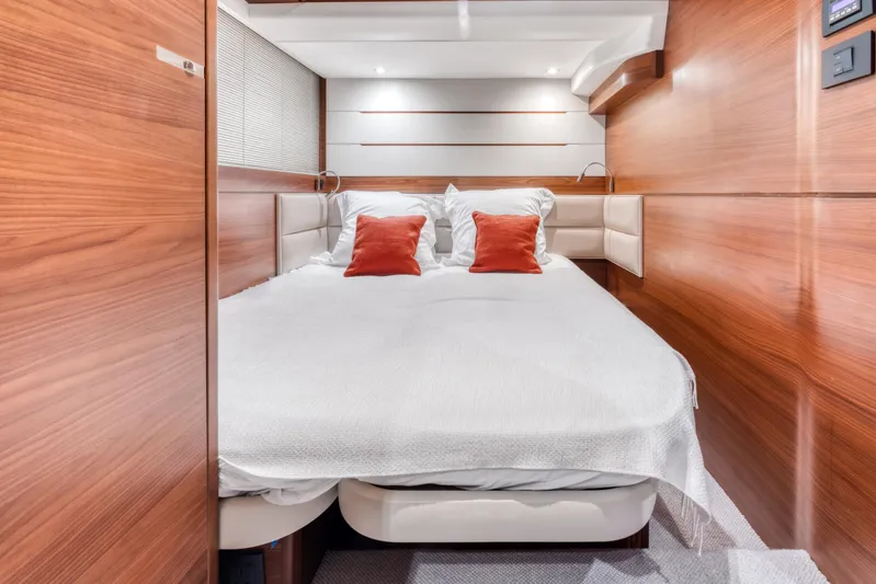  Yacht Photos Pics Luxurious cabin interior of 2016 Princess 68 yacht with wood paneling and cozy bedding.