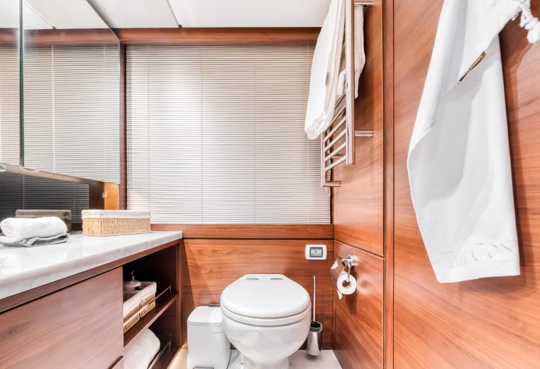  Yacht Photos Pics Luxurious yacht bathroom with wooden accents, featuring a toilet and modern amenities. Princess 68, 2016.