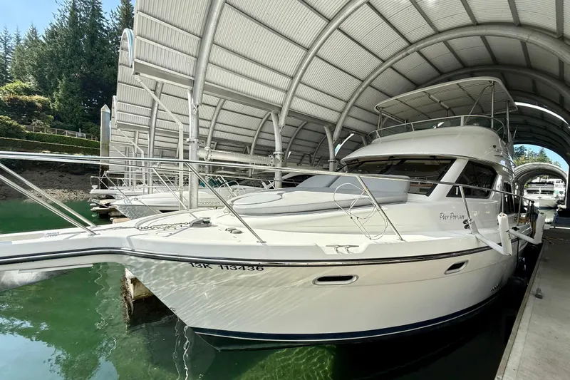 Pier Pressure Yacht Photos Pics 1999 Bayliner 3788 Command Bridge Motoryacht docked under a covered marina.