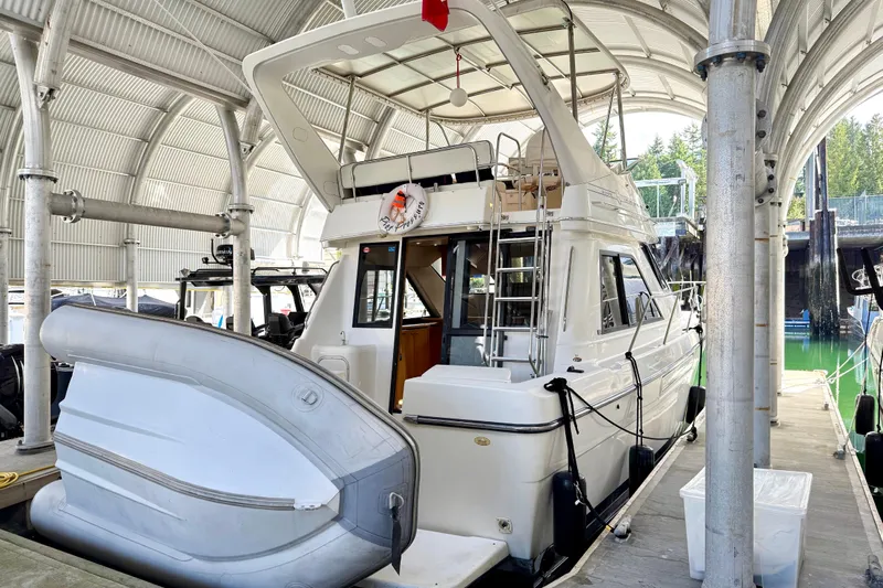 Pier Pressure Yacht Photos Pics 1999 Bayliner 3788 Command Bridge Motoryacht docked under a covered marina.
