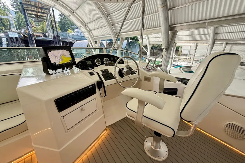 Pier Pressure Yacht Photos Pics 1999 Bayliner 3788 Command Bridge Motoryacht helm with navigation system and captain's chair.