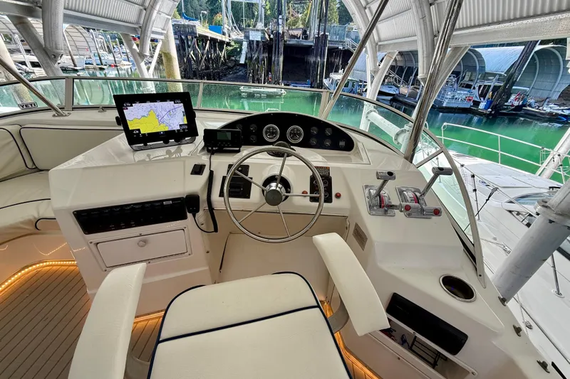 Pier Pressure Yacht Photos Pics 1999 Bayliner 3788 Command Bridge Motoryacht helm with navigation equipment and marina view.