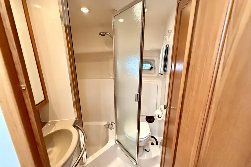 Pier Pressure Yacht Photos Pics 1999 Bayliner 3788 Command Bridge Motoryacht bathroom with shower, sink, and toilet.