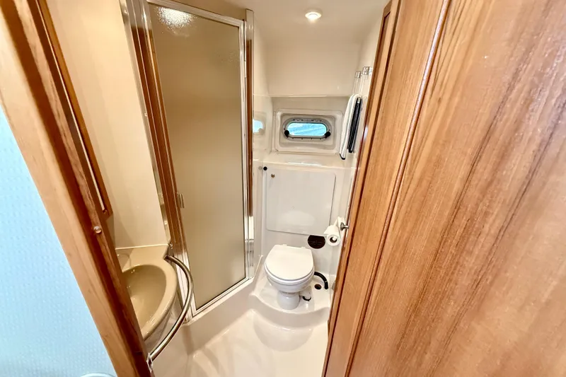 Pier Pressure Yacht Photos Pics 1999 Bayliner 3788 Command Bridge Motoryacht bathroom with shower, sink, and porthole window.