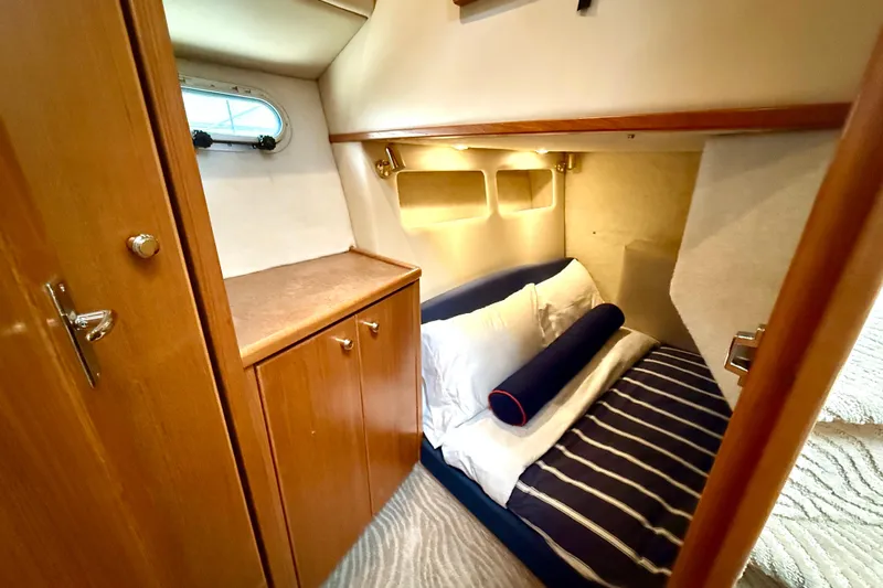 Pier Pressure Yacht Photos Pics Cozy cabin interior of 1999 Bayliner 3788 Command Bridge Motoryacht with striped bedding.