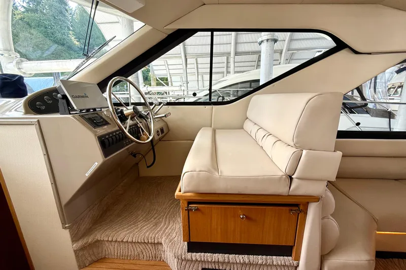 Pier Pressure Yacht Photos Pics 1999 Bayliner 3788 Command Bridge Motoryacht interior with helm station and beige seating.