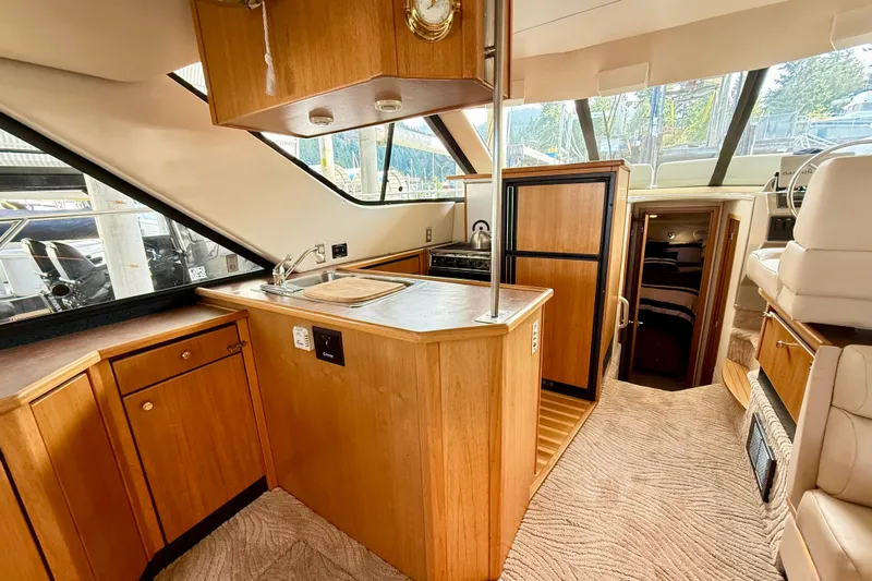 Pier Pressure Yacht Photos Pics 1999 Bayliner 3788 Command Bridge Motoryacht interior with kitchen and seating area.