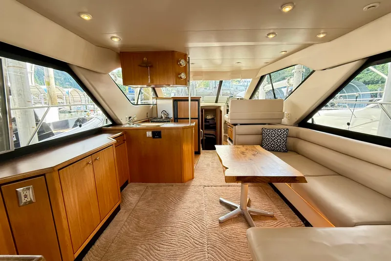 Pier Pressure Yacht Photos Pics Interior of 1999 Bayliner 3788 Command Bridge Motoryacht with wood cabinetry and seating area.