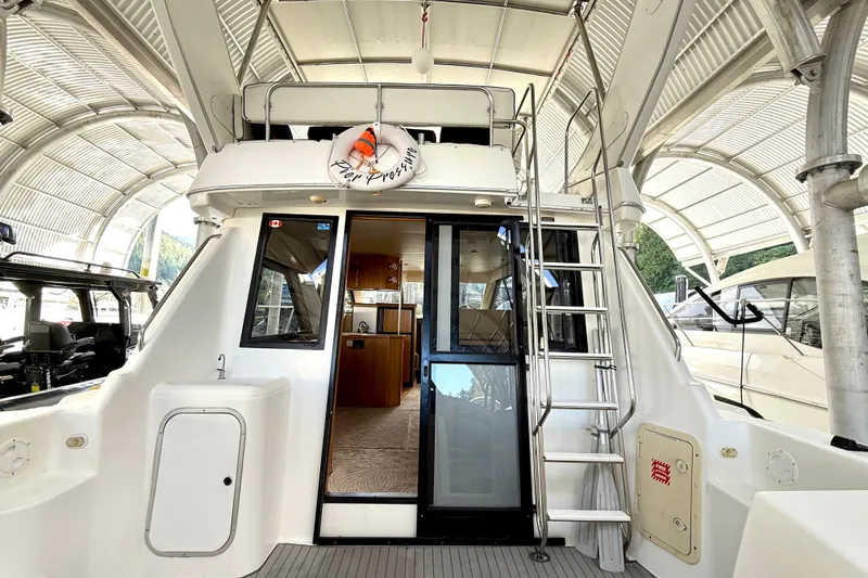Pier Pressure Yacht Photos Pics 1999 Bayliner 3788 Command Bridge Motoryacht, rear view with ladder and interior glimpse.