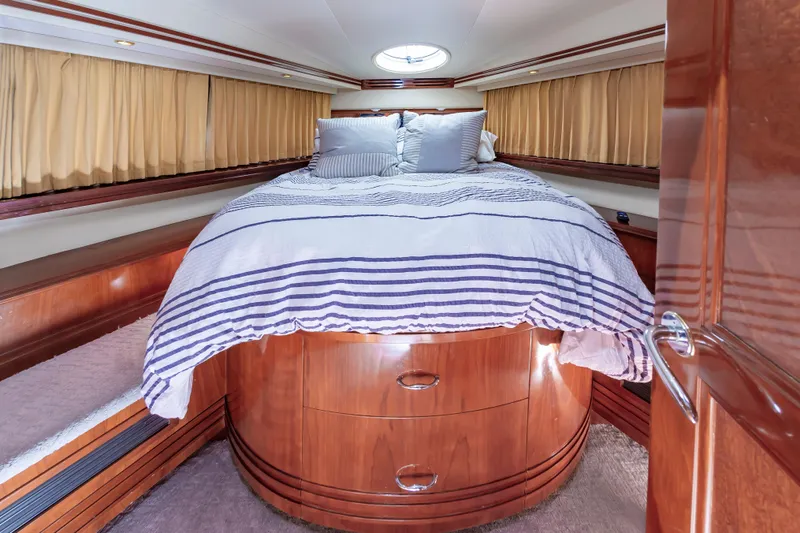 Spring Break Yacht Photos Pics Luxurious bedroom in 2004 Carver 56 Voyager SE yacht with wood cabinetry and striped bedding.