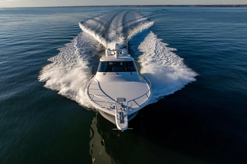 What A Country Yacht Photos Pics 2022 Viking 54 Sport Coupe cruising on open water, creating dynamic wake patterns.