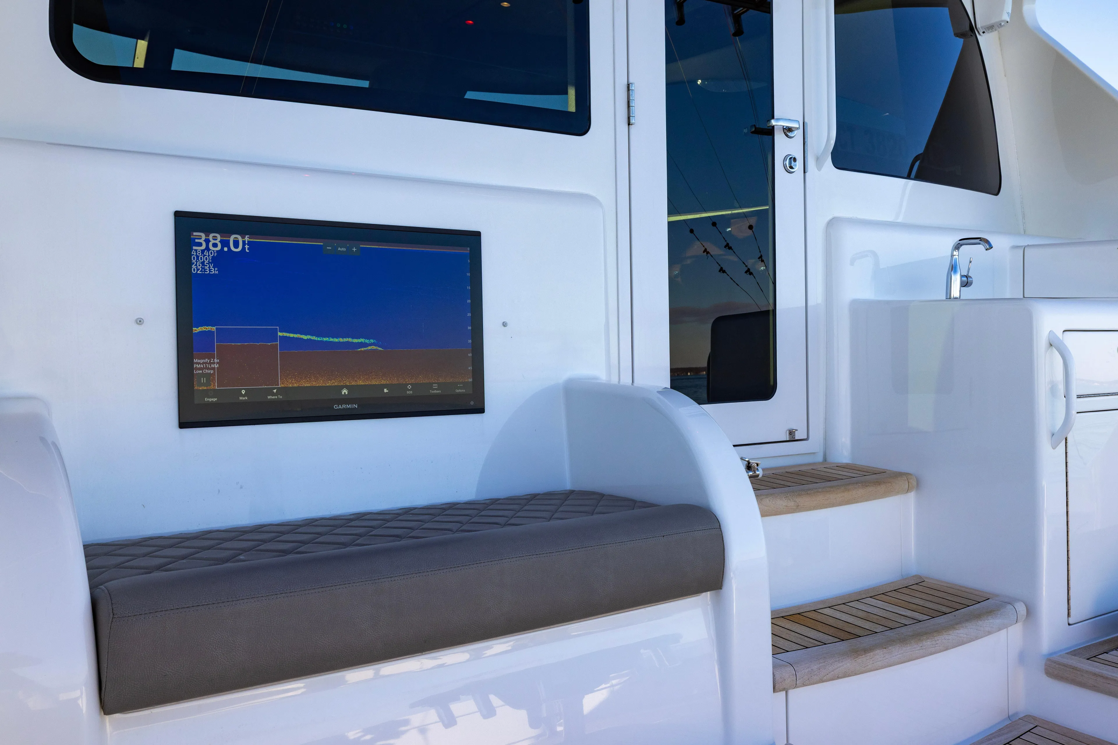 What A Country Yacht Photos Pics 2022 Viking 54 Sport Coupe interior with sonar display and cushioned seating.