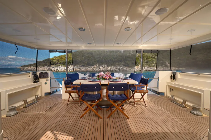  Yacht Photos Pics Luxurious 1992 Posillipo Technema 82 yacht deck with elegant dining setup and scenic ocean view.