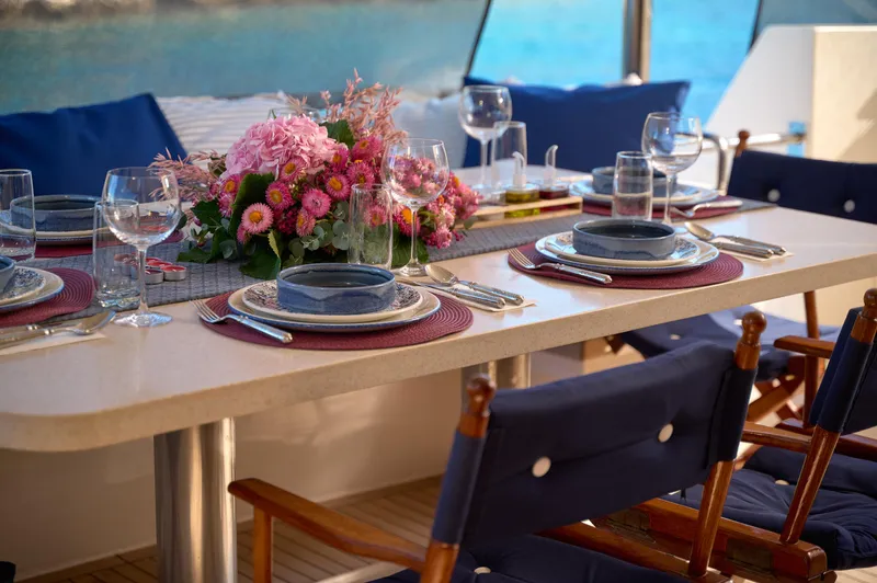  Yacht Photos Pics Elegant dining setup on a 1992 Posillipo Technema 82 yacht with floral centerpiece.