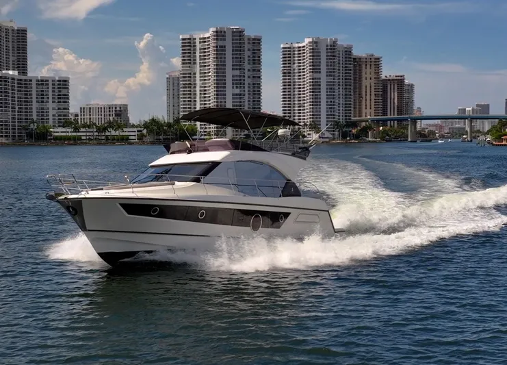 Kedem Plus Yacht Photos Pics 2021 Beneteau Monte Carlo 52 yacht cruising near city skyline on a sunny day.