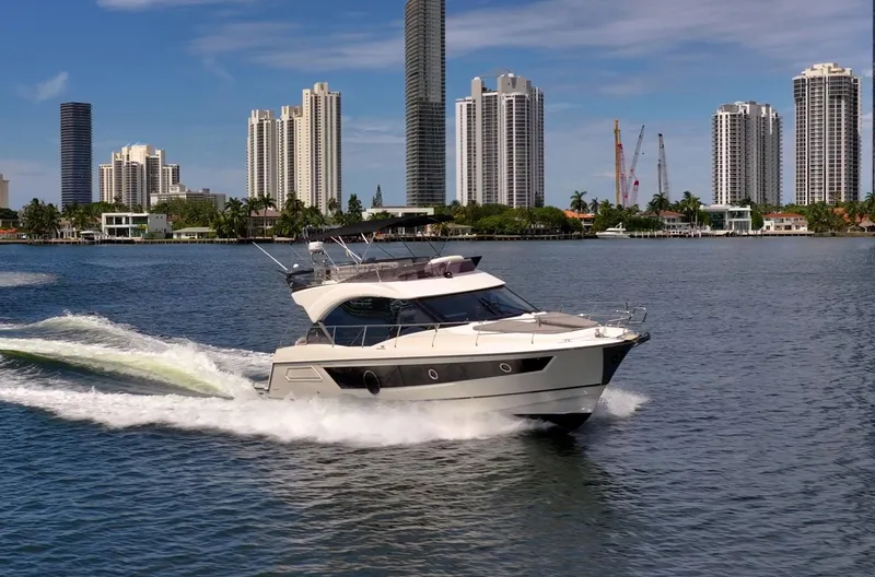 Kedem Plus Yacht Photos Pics 2021 Beneteau Monte Carlo 52 yacht cruising near city skyline.